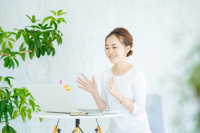 パソコンの前で話す女性